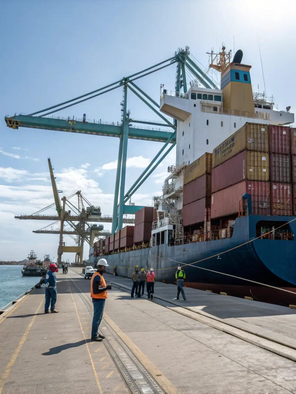 A detailed image showcasing a vehicle being loaded onto a cargo ship at a bustling port, emphasizing the global reach of Sandstorm Import LLC's services.